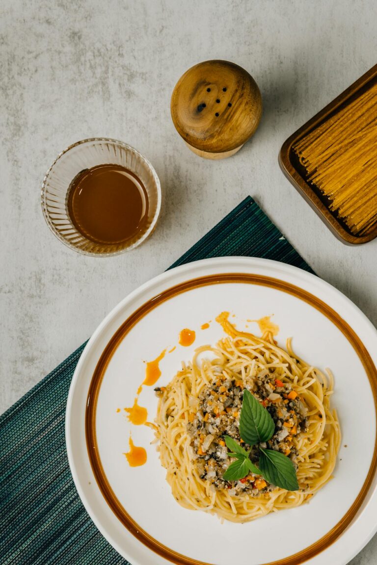 A top-down view of spaghetti with sauce and basil, perfect for food photography enthusiasts.