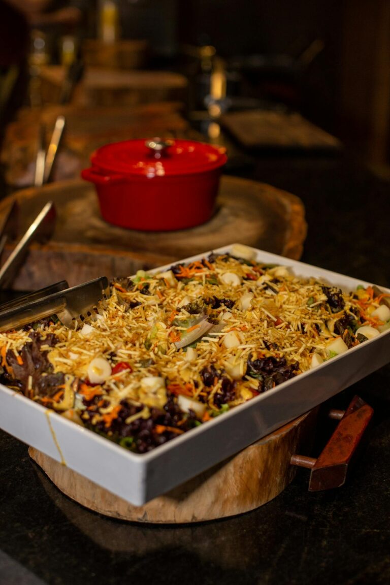 A traditional dish with vegetables and toppings presented in a white tray with stylish table setting.